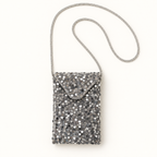 Silver sequin crossbody bag with rhinestone strap on warm ivory background