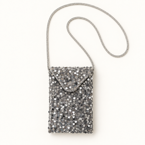 Silver sequin crossbody bag with rhinestone strap on warm ivory background